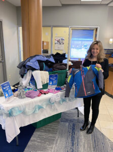 Partners Bank Team member Crystal Callhan helping with coats table for Coat drive