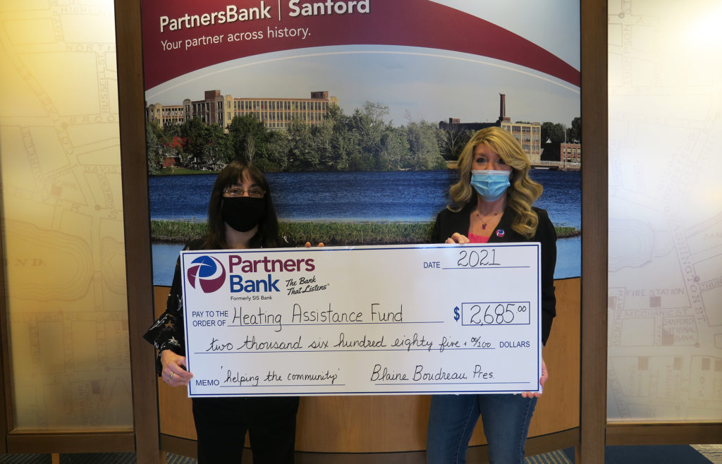 Partners Bank's Theresa Jodway (left) and Dee Richard (right) stand with a check for more than $2,600 toward heating assistance funds.
