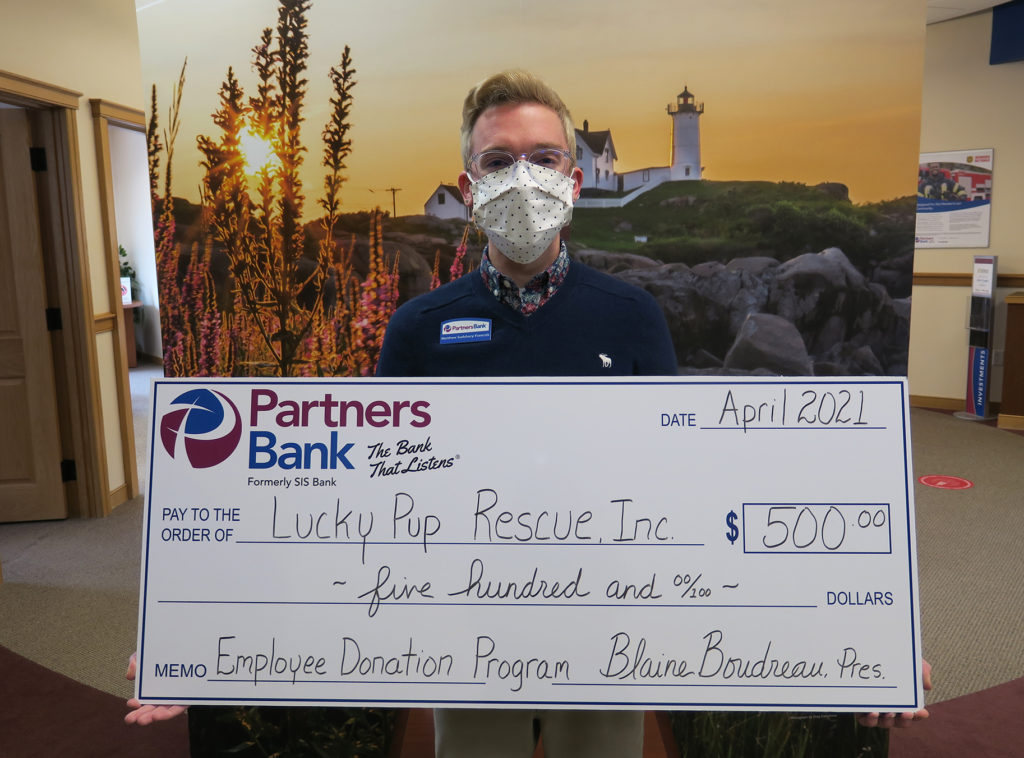 Partners Bank Assistant Branch Manager of the York location, Matthew Sundsbury-Fracois stand with a $500 check to Lucky Pup Rescue.