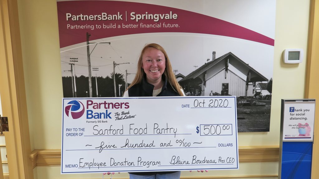 Jillian Porter stands with a big check for $500 for the Sanford Food Pantry after she was selected to choose an organization for the Bank's Employee Donation Program.