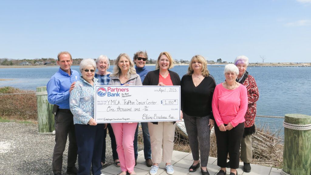 Partners Bank employees holding a $1000 check for the Employee Donation Program