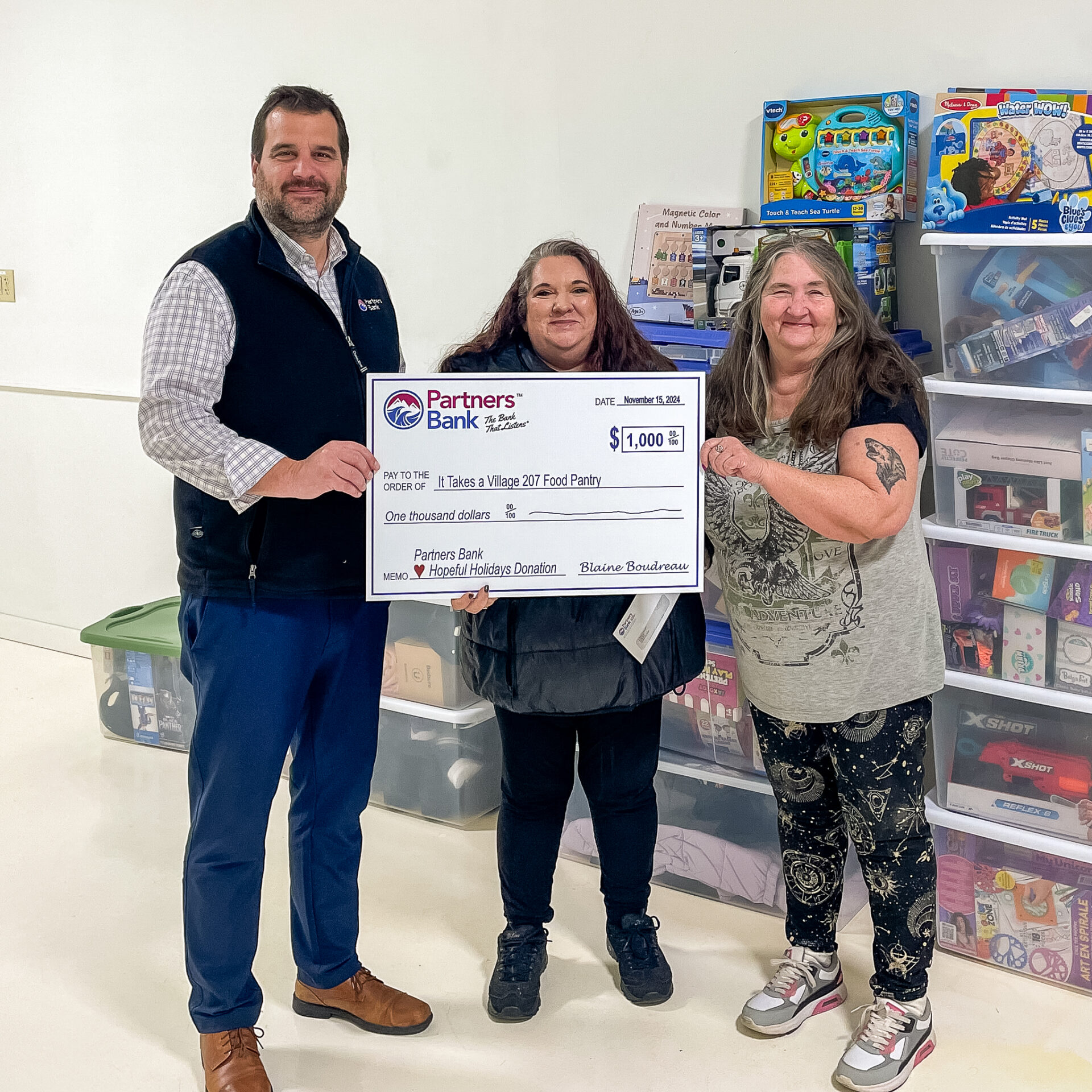 Partners Bank team members holding donation check