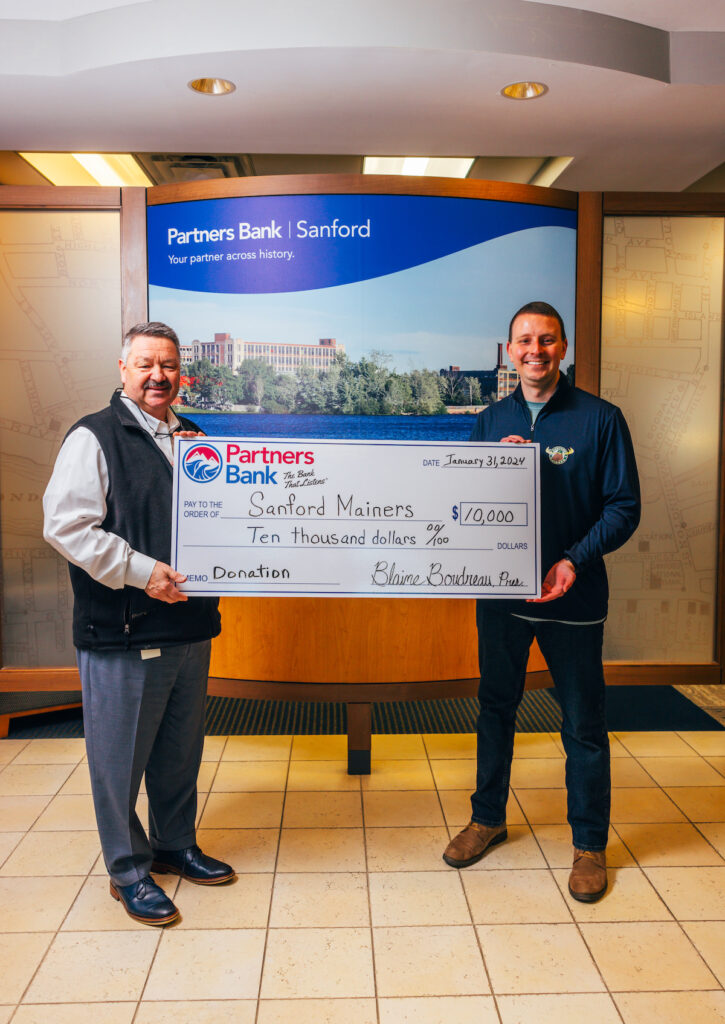 Blaine Boudreau, Partners Bank President & CEO, presents a check to Sanford Mainers organization for $10,000 as their presenting sponsor