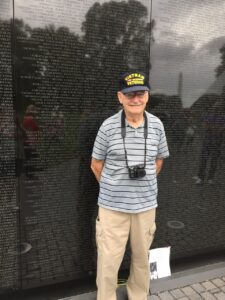 Proud Veteran Harold R. West standing in front of Vietnam veteran memorial wall