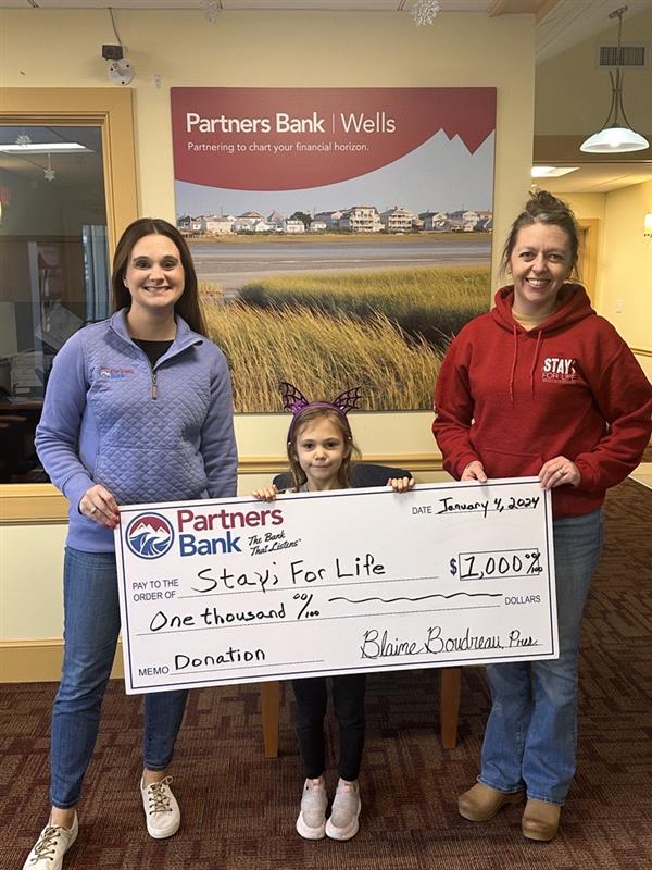 Partners Bank teammembers holding a check to Stay For Life